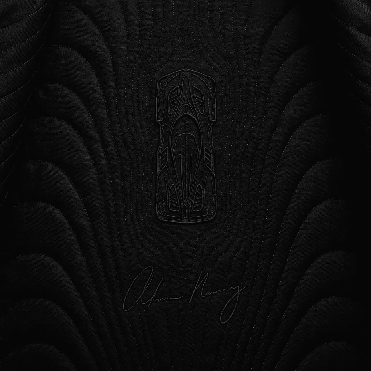 The same car from above, embroidered into the silk lining beside Adrian Newey’s signature